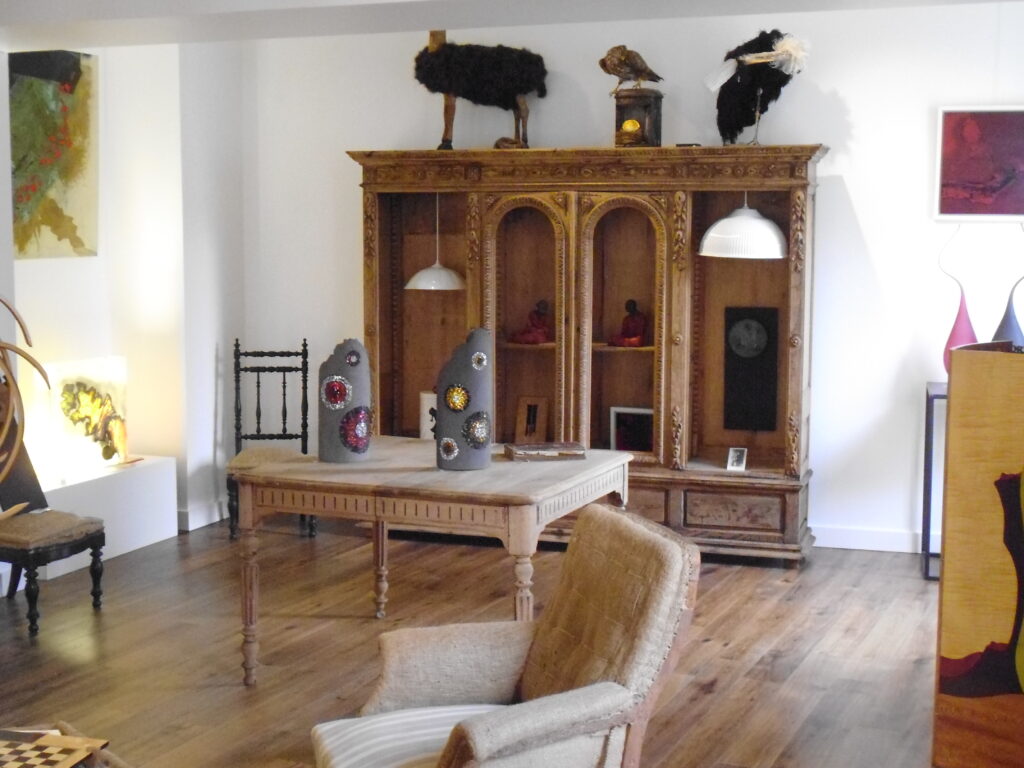 Salle d’exposition Martres Tolosane avec meubles et sculptures modernes.