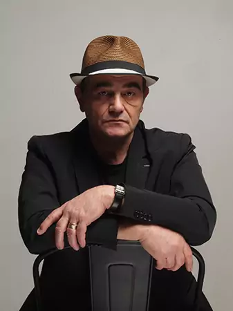 Homme portant un chapeau, assis sur une chaise, Salle d’exposition Martres Tolosane.