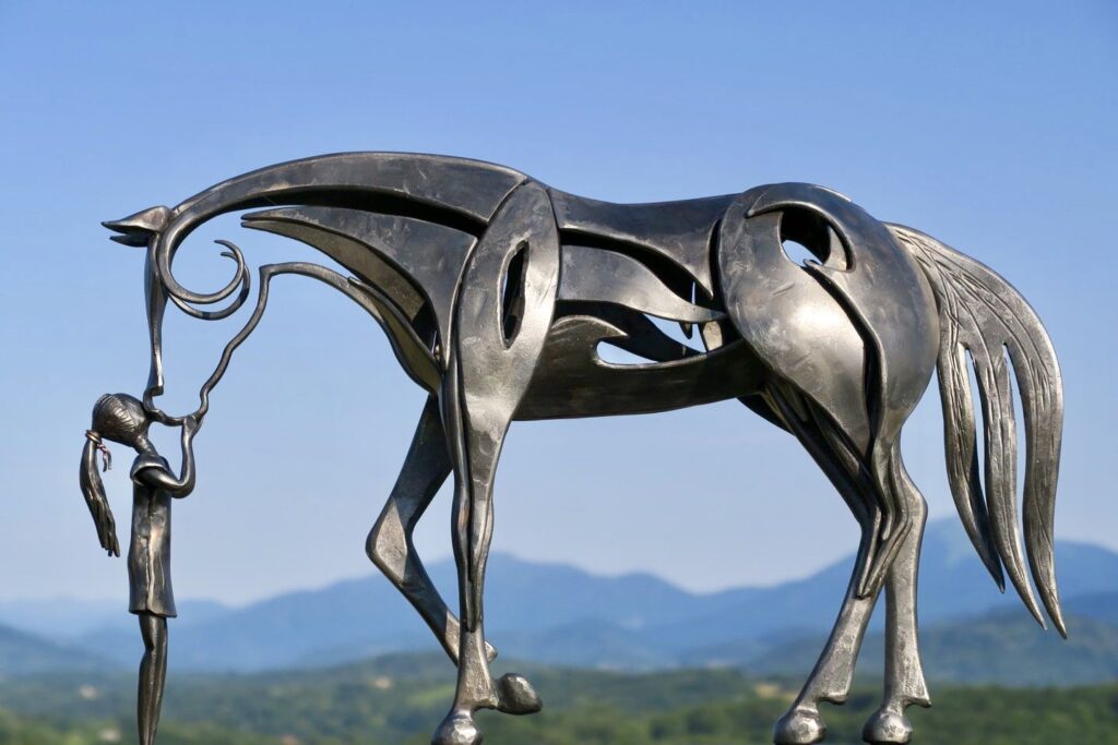 Sculpture d'un enfant interagissant avec un cheval au Grand Presbytère.