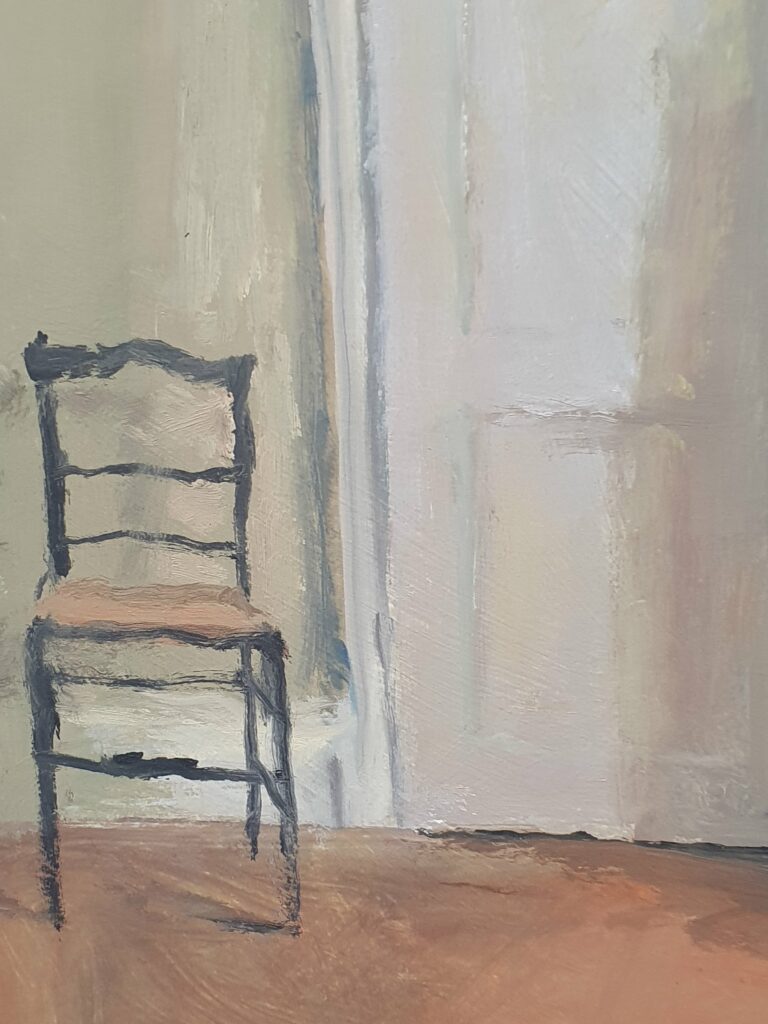 Chaise en bois devant une porte au Grand Presbytère, Salle d’exposition.