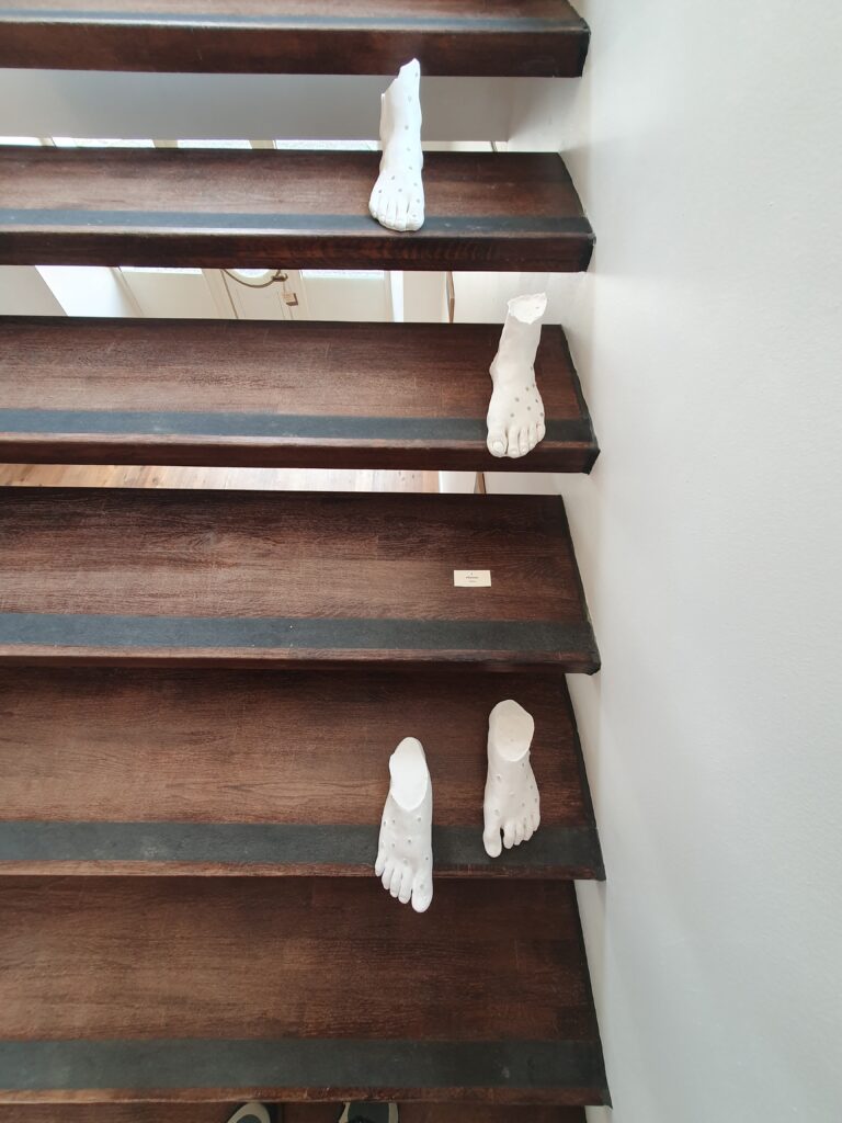 Pieds en céramique sur les marches du Grand Presbytère, Salle d’exposition.