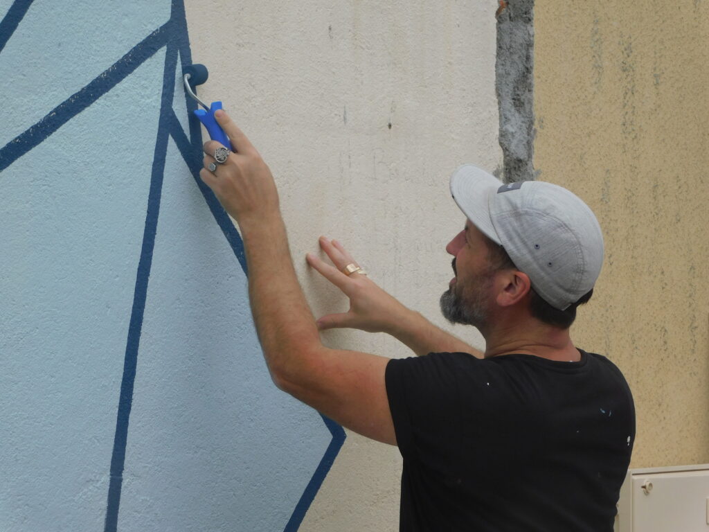 Artiste peignant un mur au Grand Presbytère, Salle d’exposition Martres Tolosane.