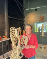 Femme souriante tenant une sculpture au Grand Presbytère Martres Tolosane.